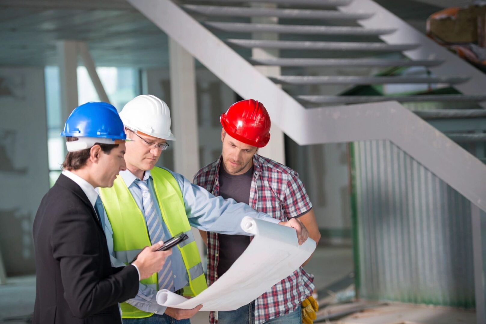 Construction workers reviewing blueprints.