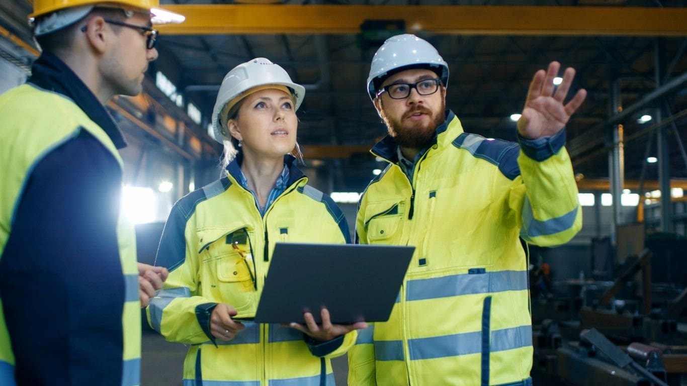 A group of people in yellow jackets and hard hats.